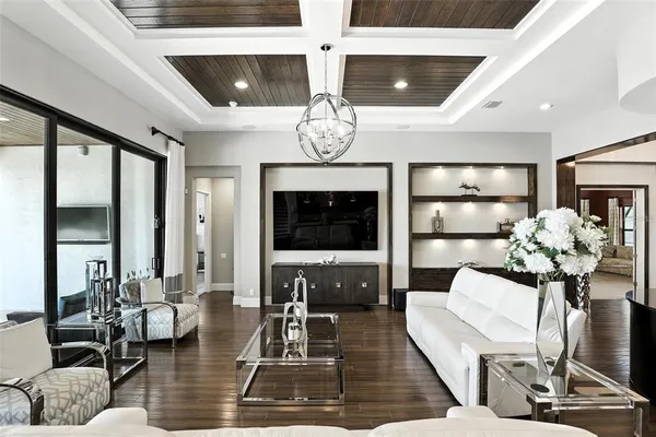 a kitchen with stainless steel appliances kitchen island granite countertop a refrigerator a stove a dining table and chairs with wooden floor