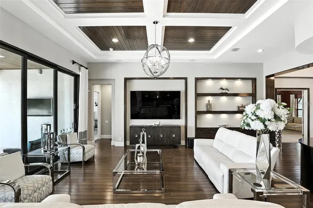 a kitchen with stainless steel appliances kitchen island granite countertop a refrigerator a stove a dining table and chairs with wooden floor