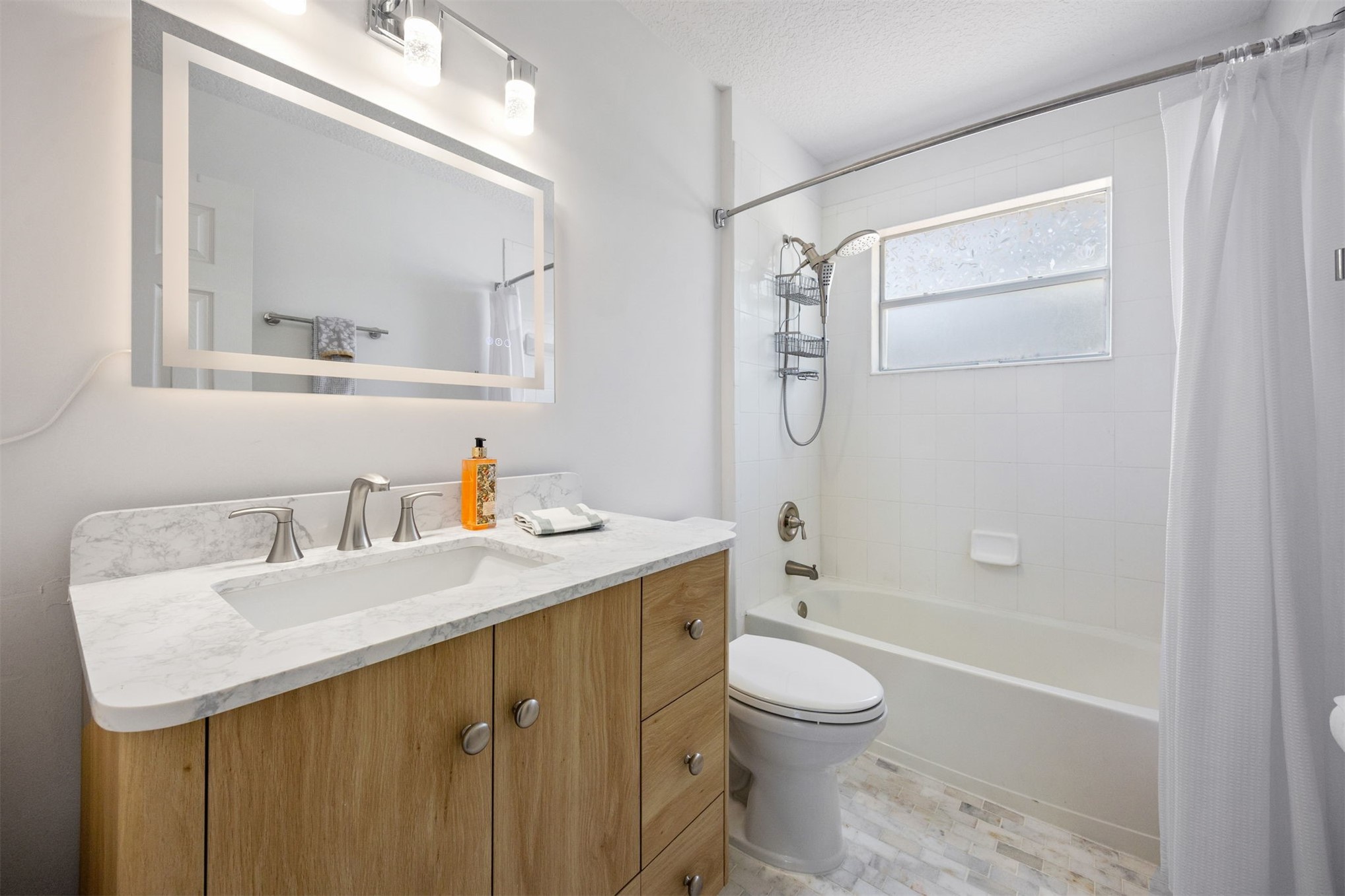 86107 Remsenburg Drive Fernandina Beach, FL 32034 - Photo 26 of 58 a bathroom with a granite countertop sink toilet a large mirror a bathtub and shower