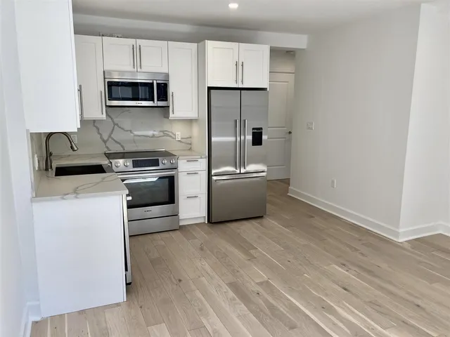 a kitchen with stainless steel appliances a refrigerator sink and microwave