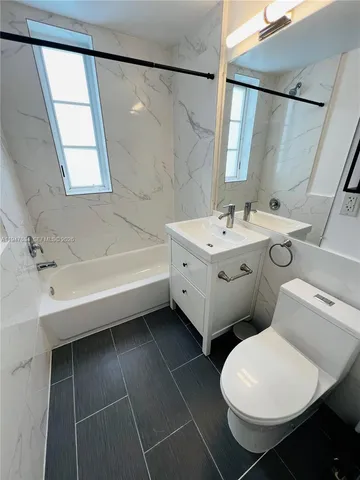a bathroom with a white toilet and a bathtub