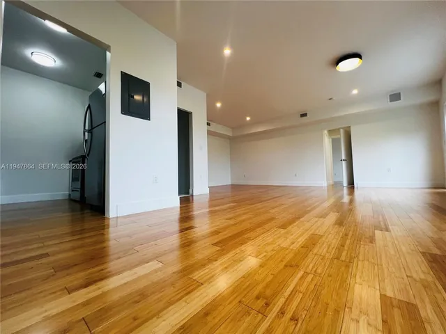 a view of a hall with wooden floor and staircase