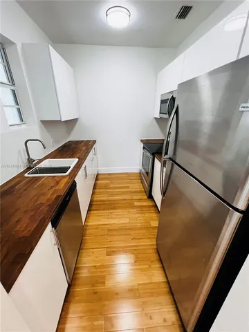 a kitchen with stainless steel appliances a stove microwave and refrigerator