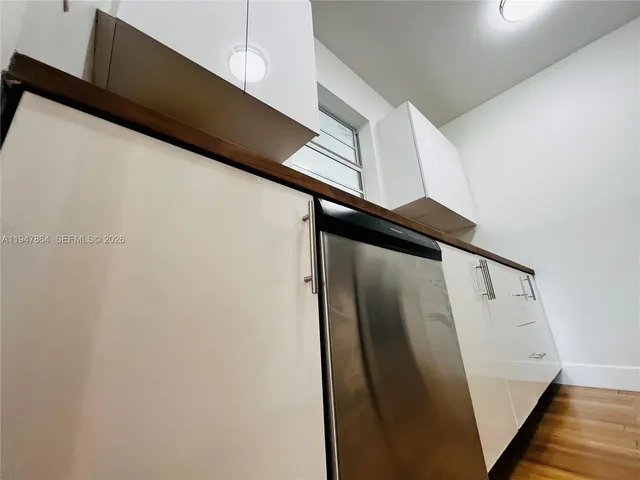 a kitchen with granite countertop white cabinets and black appliances