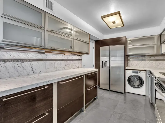 a kitchen with a refrigerator and a stove top oven