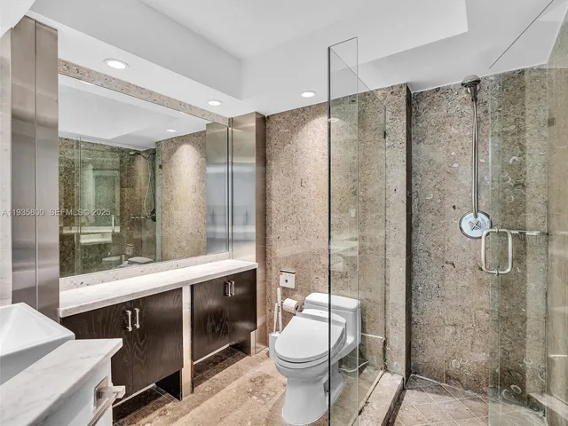 a bathroom with a granite countertop sink toilet and shower