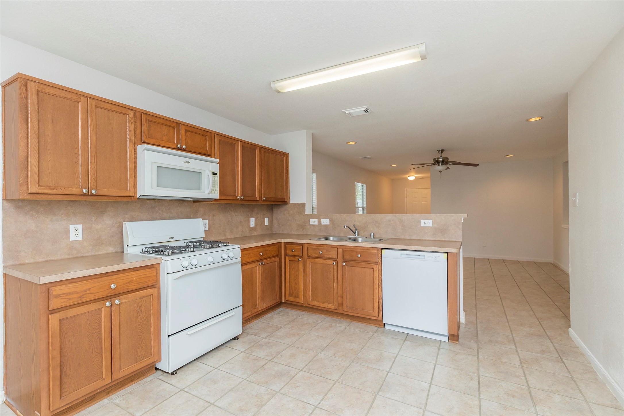 21202 Fire Wind Court Spring, TX 77379 - Photo 8 of 21 Open Kitchen. Functional kitchen with ample cabinet space with white appliances.