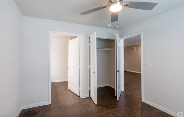 an empty room with wooden floor and closet
