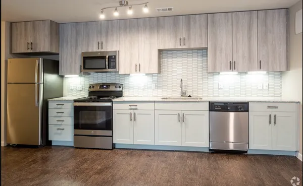 a kitchen with granite countertop white cabinets and stainless steel appliances