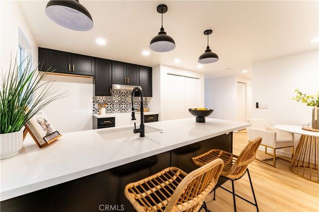 a kitchen with kitchen island stainless steel appliances a sink and living room view