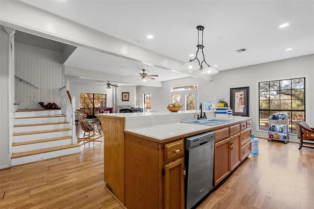 a kitchen with stainless steel appliances granite countertop a kitchen island a stove and a wooden floors