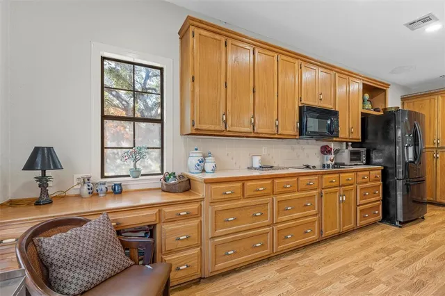 a kitchen with stainless steel appliances granite countertop a sink dishwasher stove and refrigerator with wooden floor