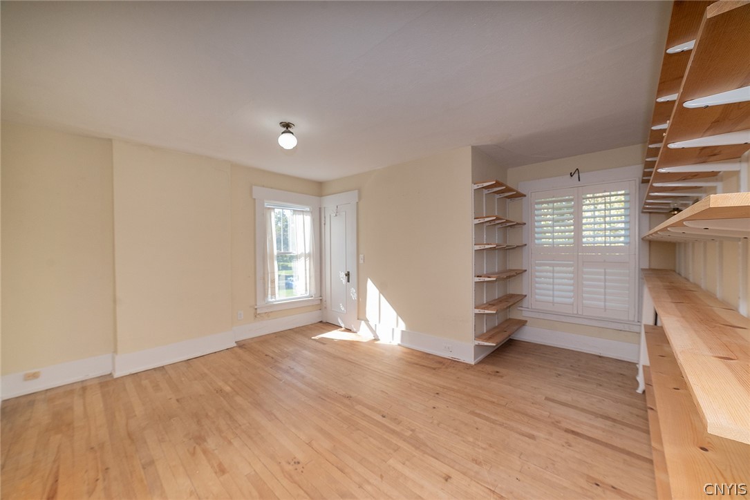 167 Beverly Road Syracuse, NY 13207 - Photo 33 of 50 Hardwood flooring and integrated wooden shelving define this versatile, light-filled interior space.