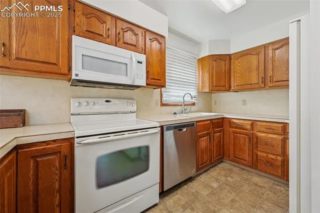 a kitchen with granite countertop cabinets stainless steel appliances and a sink