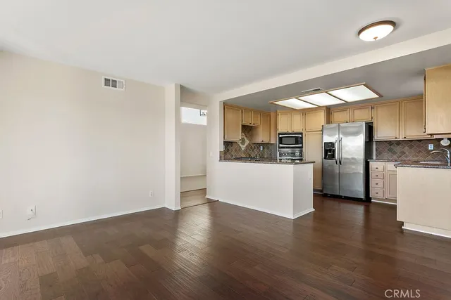 a kitchen with stainless steel appliances granite countertop a refrigerator and a sink