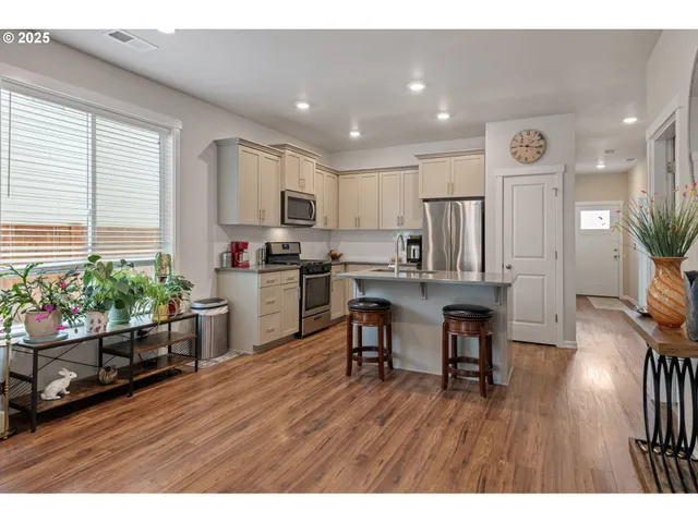 a kitchen with stainless steel appliances a stove a sink a microwave a refrigerator and cabinets