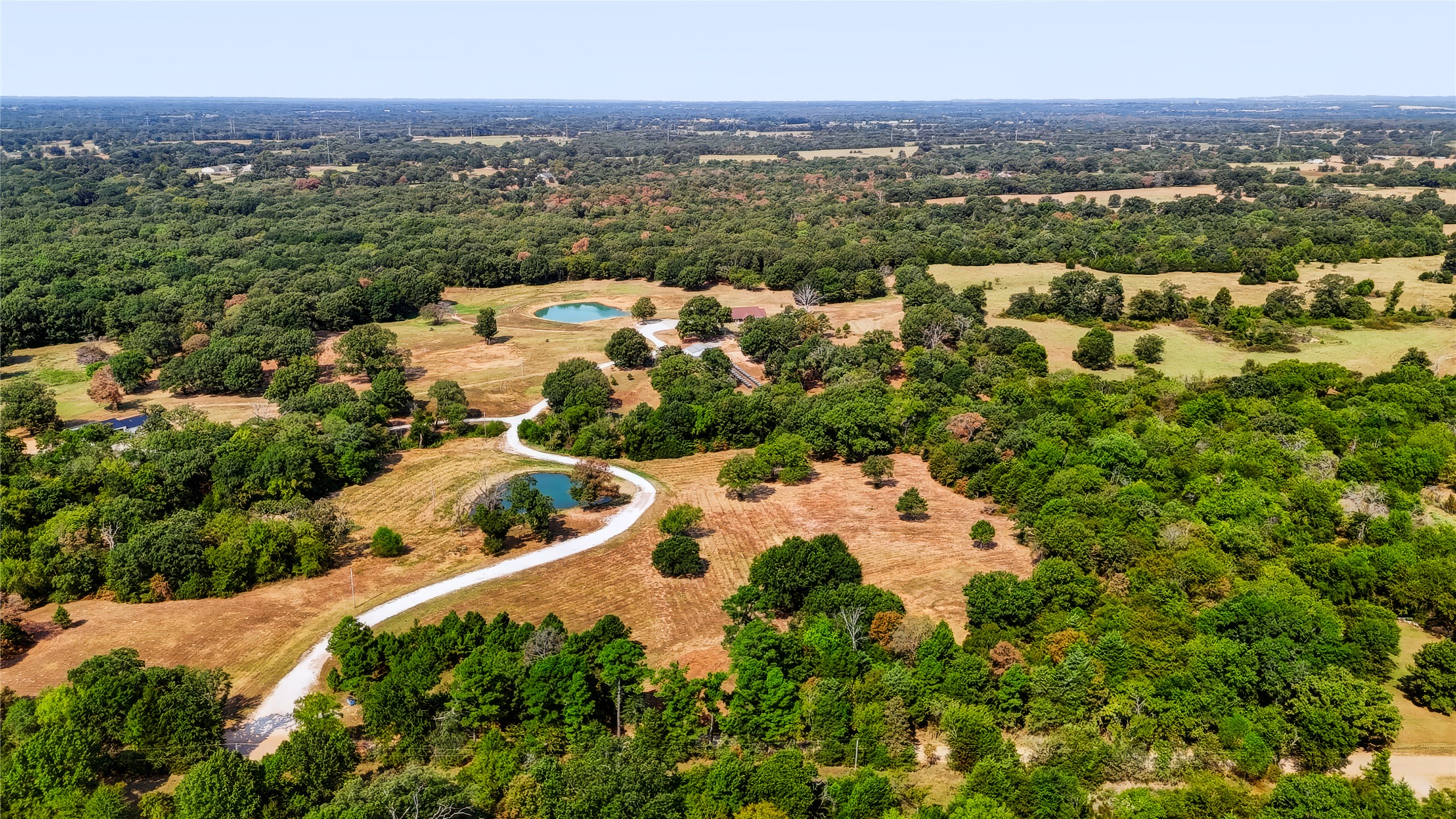 3607 South Half Bank Road Atoka, OK 74525 - Photo 67 of 82 Expansive acreage featuring mature trees, two distinct ponds, and a winding gravel drive
