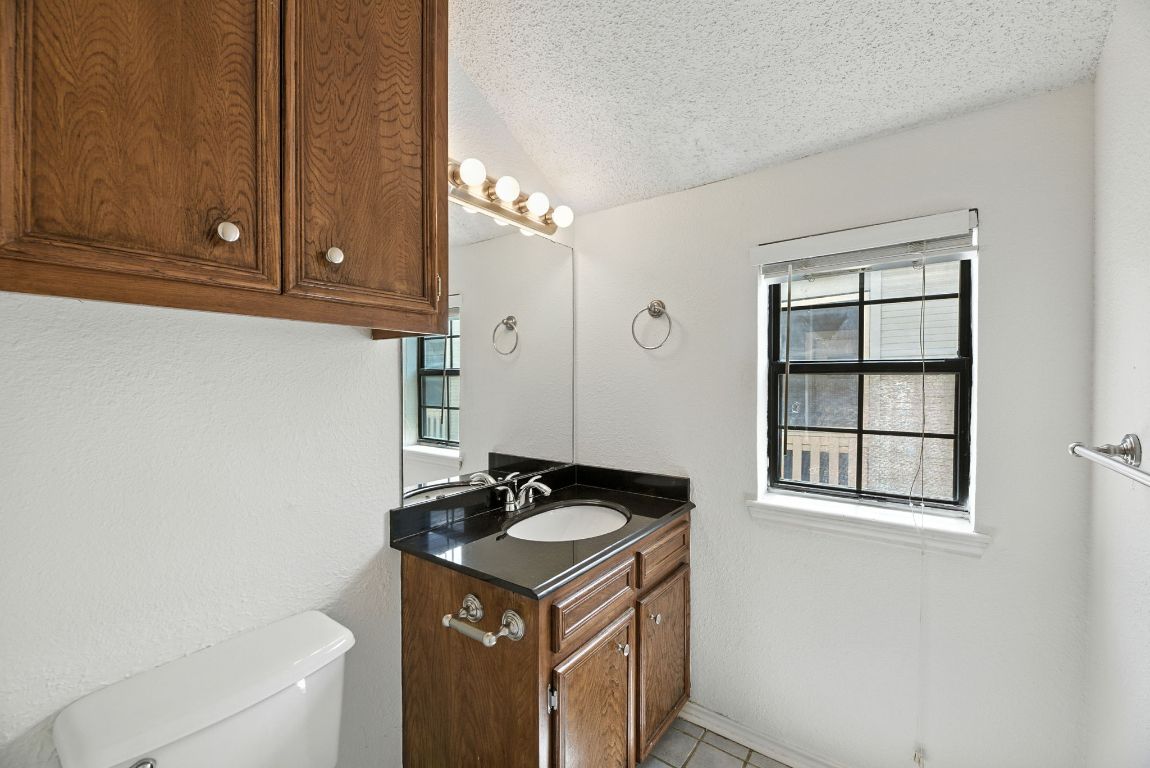 4409 Speedway, Unit 201 Austin, TX 78751 - Photo 13 of 16 Bathroom featuring a textured ceiling, vanity, light tile patterned flooring, and a textured wall