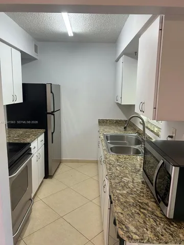 a kitchen with a sink stove and refrigerator