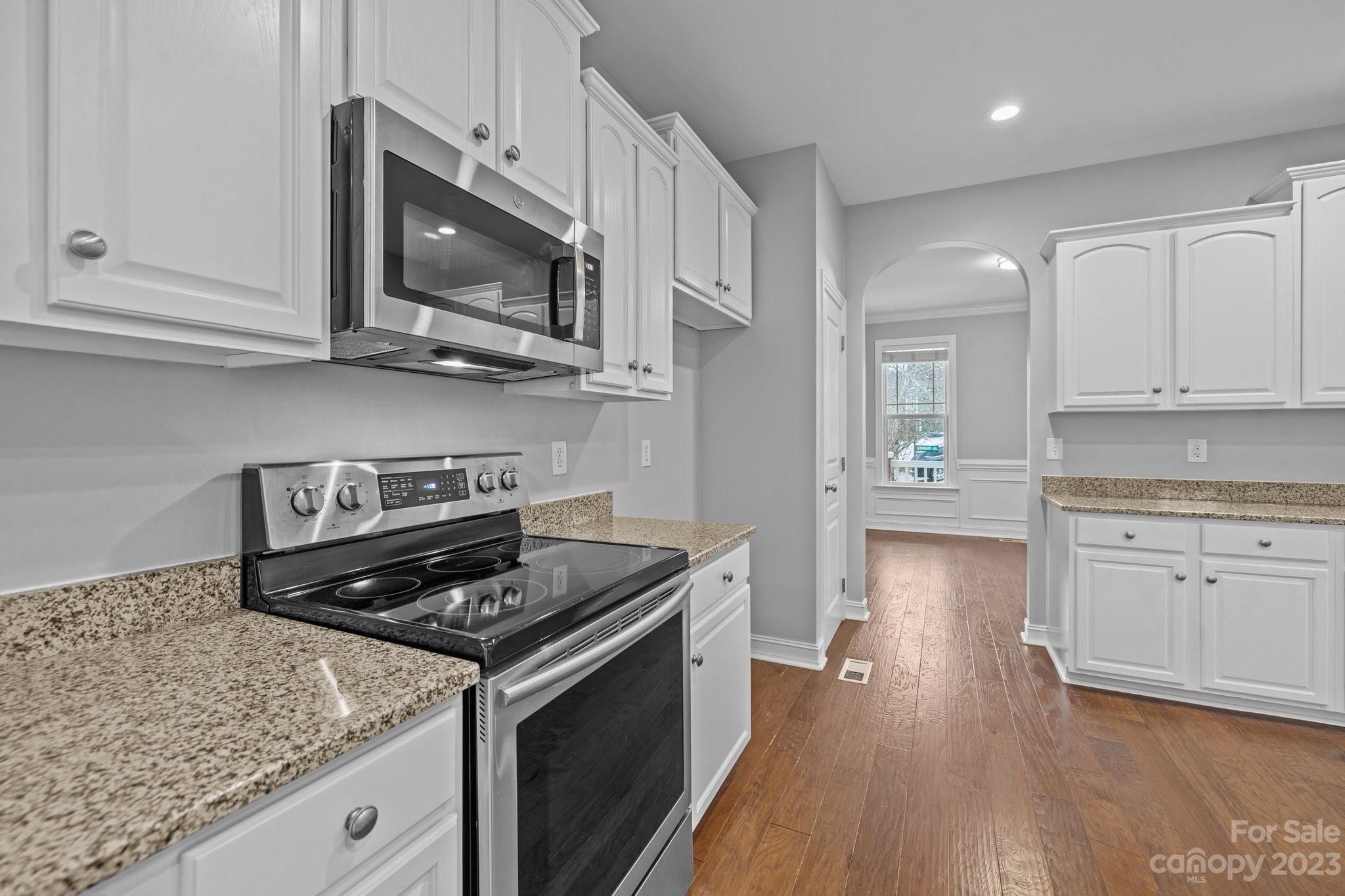 10304 Glenmeade Road Cornelius, NC 28031 - Photo 25 of 47 a kitchen with stainless steel appliances granite countertop a stove a sink and a microwave