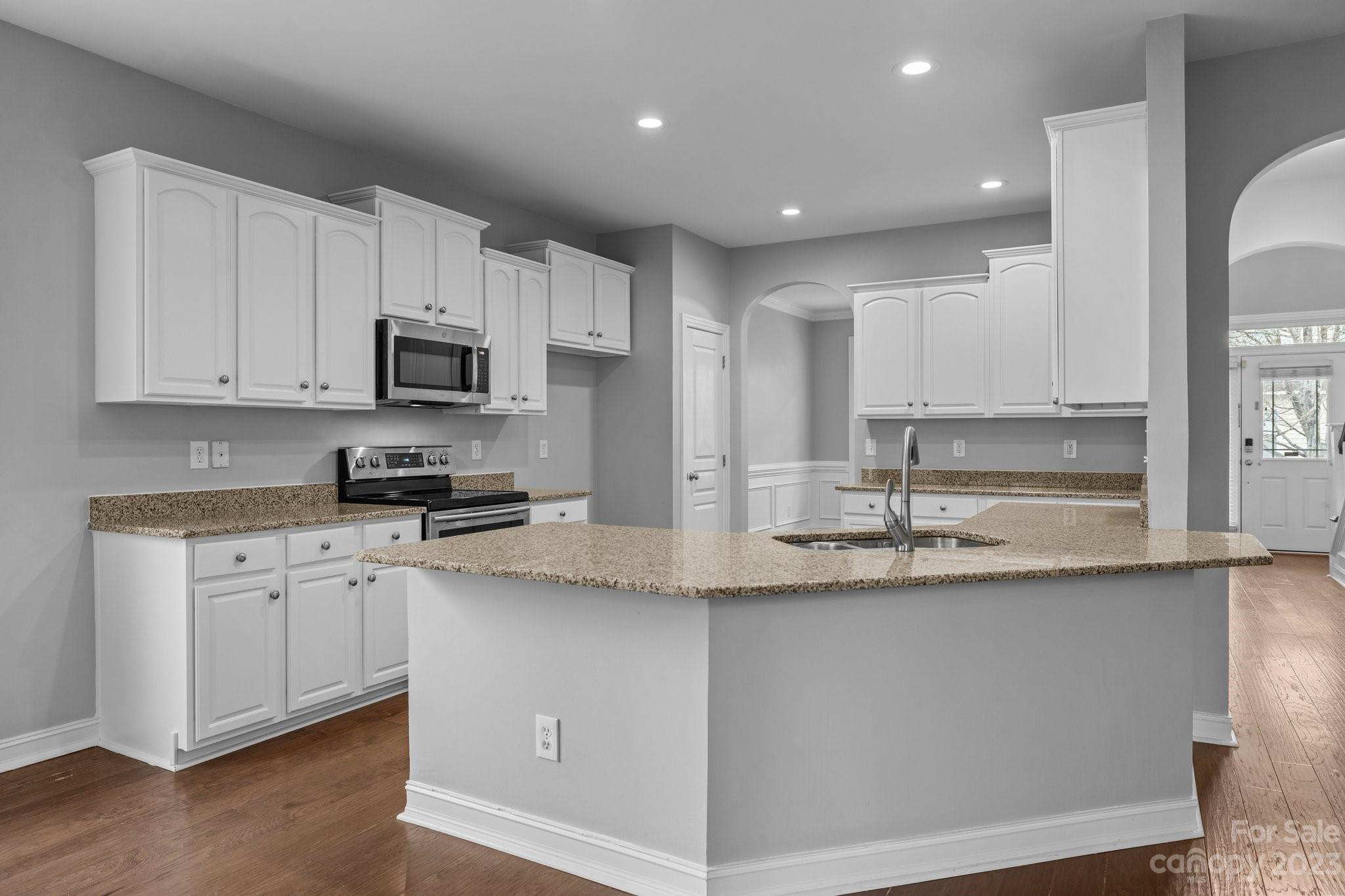 10304 Glenmeade Road Cornelius, NC 28031 - Photo 26 of 47 a kitchen with stainless steel appliances granite countertop a sink a stove and cabinets