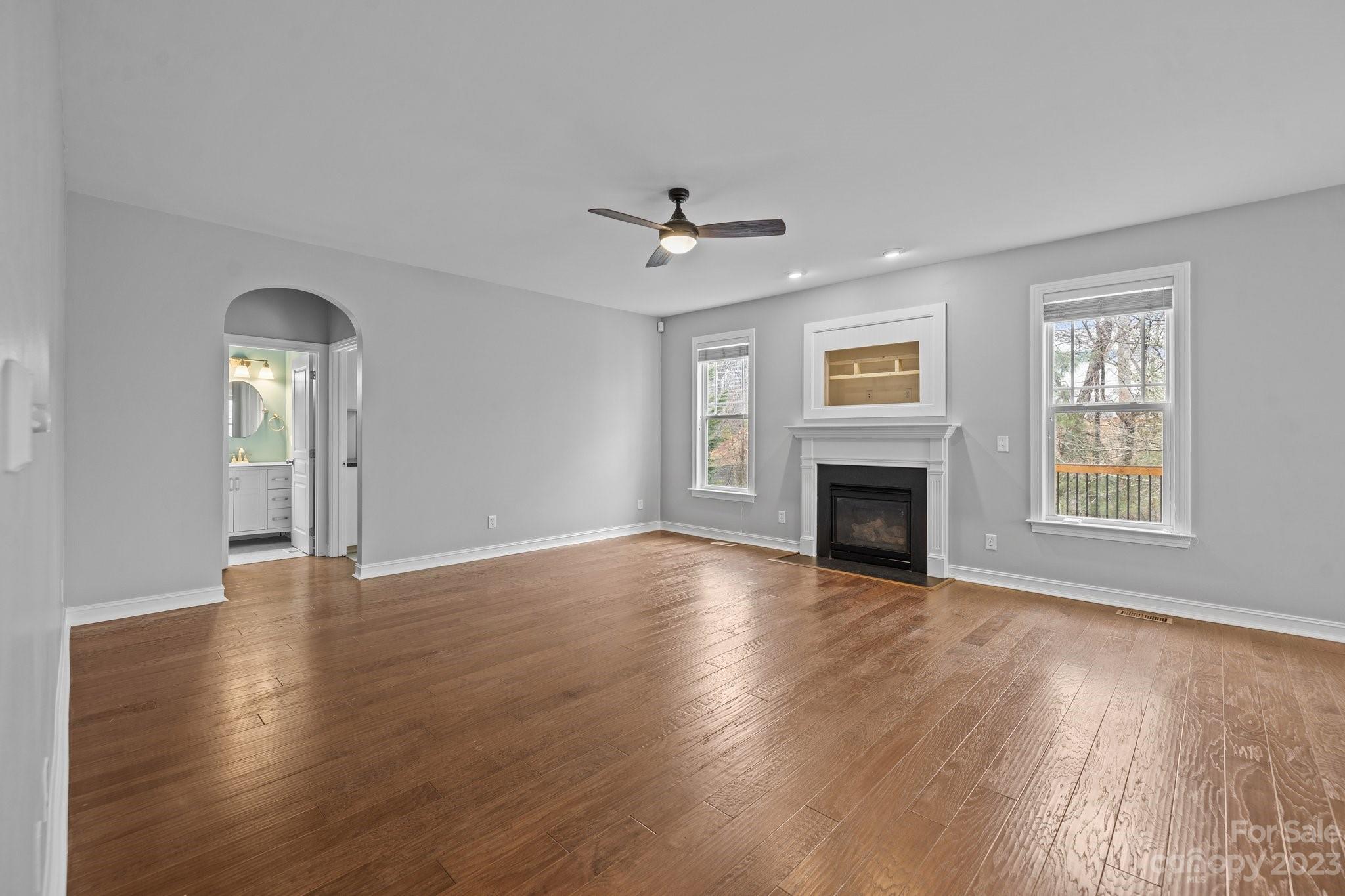 10304 Glenmeade Road Cornelius, NC 28031 - Photo 29 of 47 an empty room with wooden floor fireplace and windows