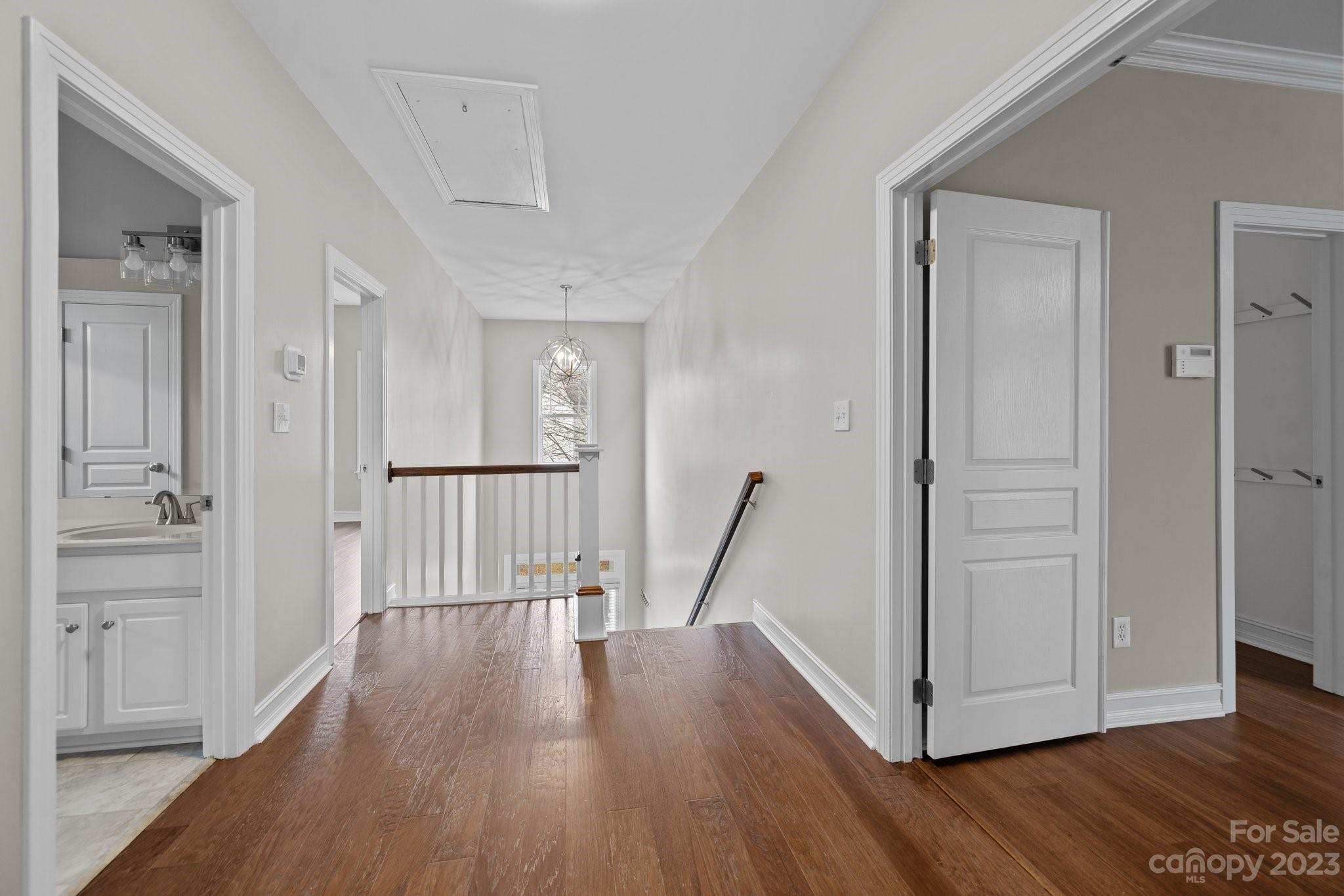 10304 Glenmeade Road Cornelius, NC 28031 - Photo 32 of 47 a view of a hallway with wooden floor and staircase