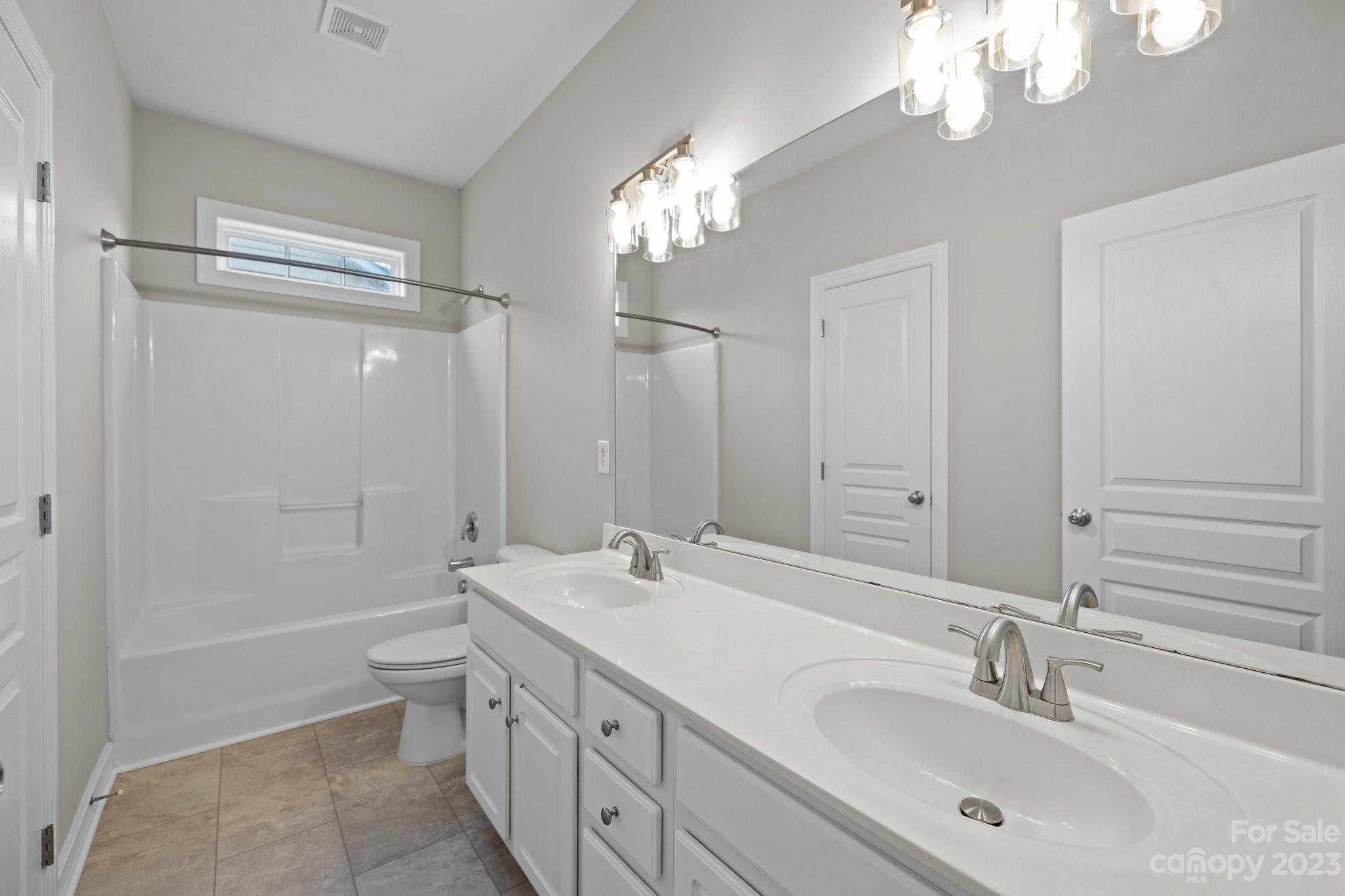 10304 Glenmeade Road Cornelius, NC 28031 - Photo 34 of 47 a bathroom with double vanity sinks a toilet a shower a vanity and a mirror