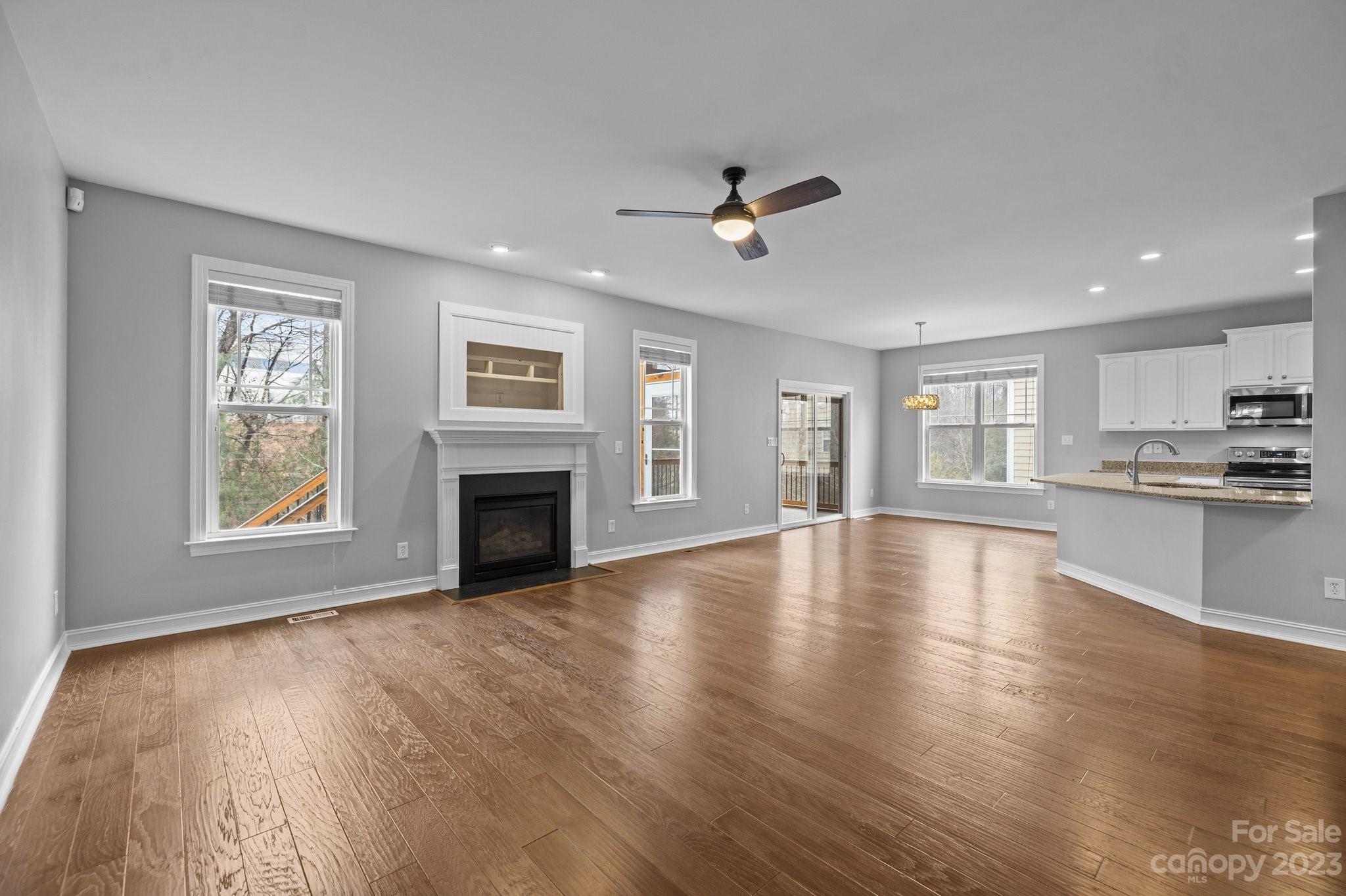 10304 Glenmeade Road Cornelius, NC 28031 - Photo 4 of 47 a view of empty room with wooden floor and fireplace
