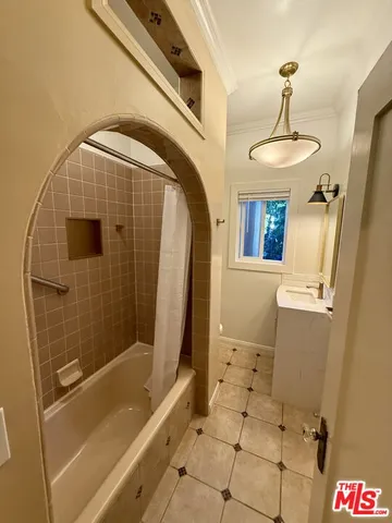 a view of a backyard with table and chairs potted plants and large tree