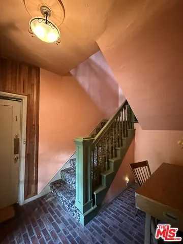 a view of a hallway with wooden floor and stairs