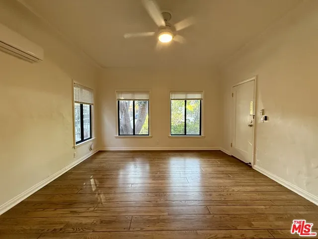 a view of empty room with wooden floor and window