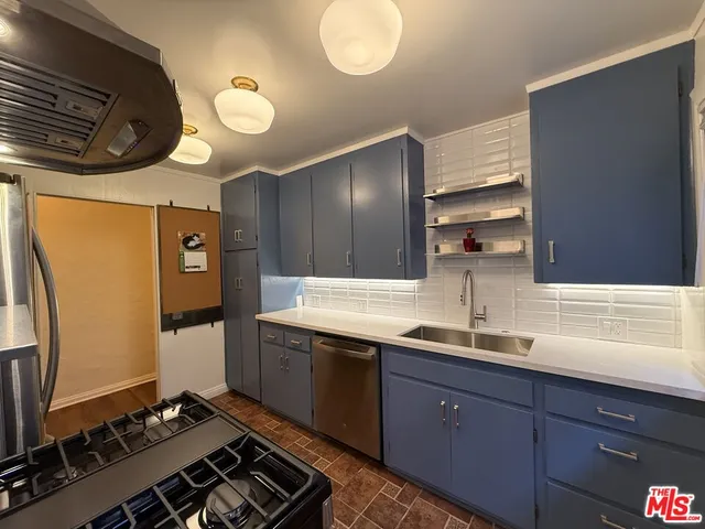 a kitchen with stainless steel appliances granite countertop a refrigerator and a stove top oven
