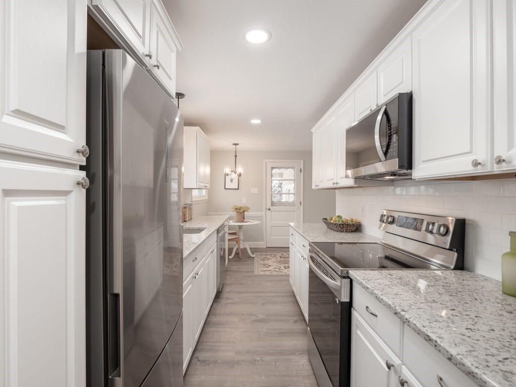 39 Marilyn Road Andover, MA 01810 - Photo 14 of 28 a kitchen with stainless steel appliances granite countertop a sink and dishwasher a stove top oven with wooden floor