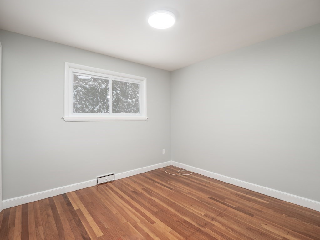 39 Marilyn Road Andover, MA 01810 - Photo 18 of 28 a view of an empty room with wooden floor and a window