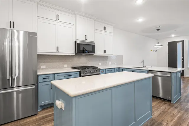 a kitchen with stainless steel appliances a refrigerator sink and microwave