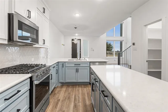 a kitchen with granite countertop a sink stove and cabinets
