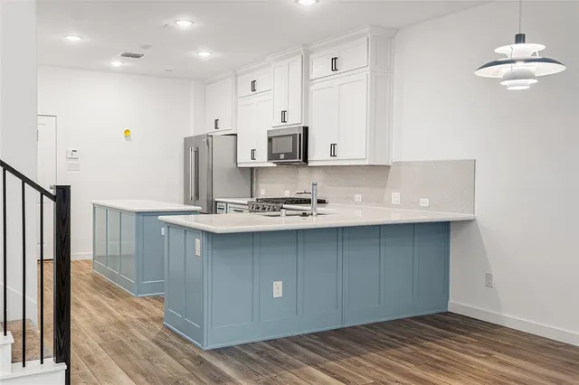 a kitchen with stainless steel appliances granite countertop a sink a stove and a refrigerator