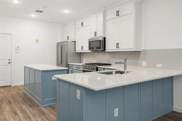 a kitchen with stainless steel appliances a sink stove and refrigerator