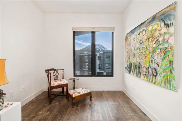 a view of a room with wooden floor and a bench