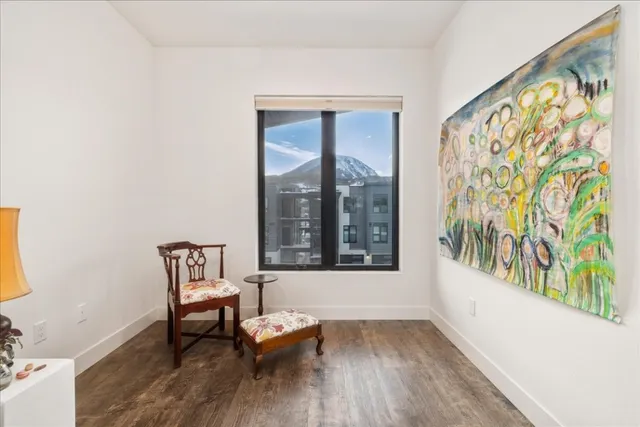 a view of a room with wooden floor and a bench