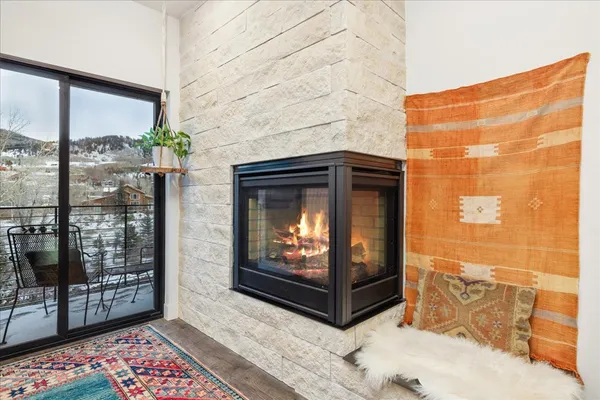 a living room with a fireplace and a floor to ceiling window