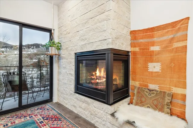 a living room with a fireplace and a floor to ceiling window