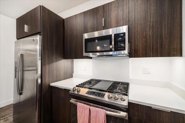 a kitchen with stainless steel appliances wooden cabinets and a stove