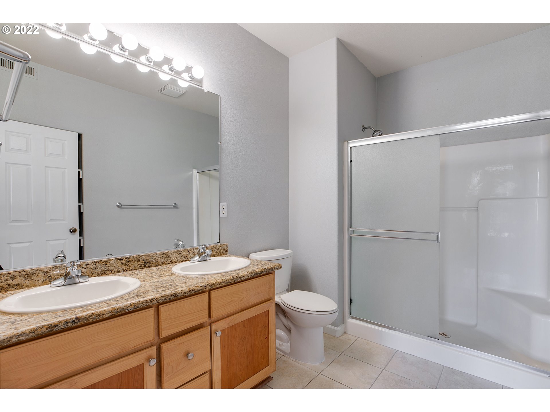 595 Springtree Lane West Linn, OR 97068 - Photo 15 of 28 a bathroom with a granite countertop sink toilet a large mirror a shower and vanity