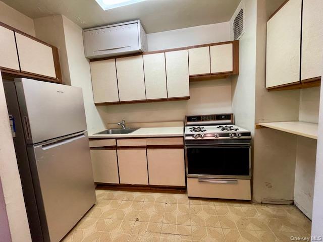 48-21 40th Street, Unit 2C Queens, NY 11104 - Photo 5 of 7 a kitchen with stainless steel appliances granite countertop a refrigerator a sink and a stove