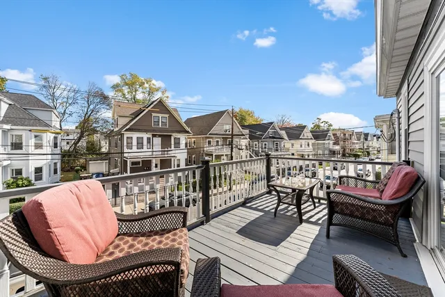 a view of a roof deck with couches chairs and wooden floor