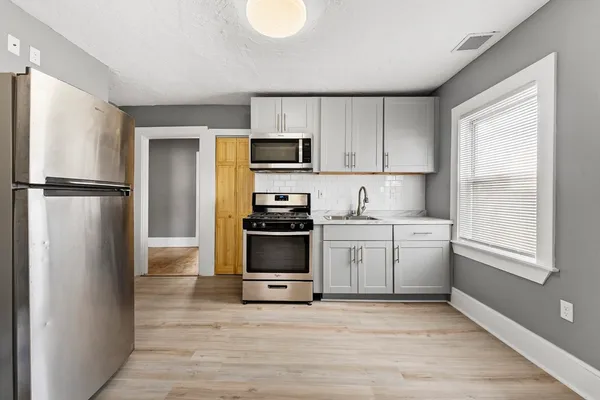 a view of an empty room with wooden floor