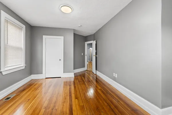 a view of an empty room with wooden floor