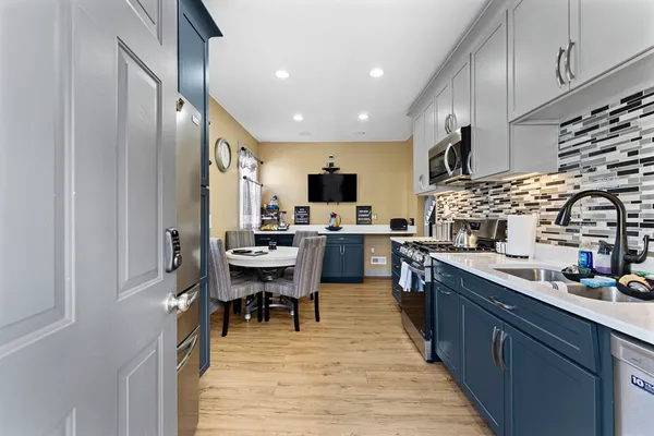 a kitchen with stainless steel appliances lots of counter top space and furniture